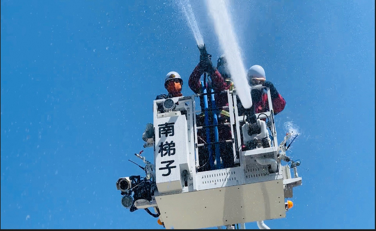 梯子の上から放水している画像