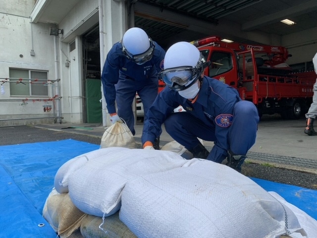 土のうを積み上げていく若手職員の写真