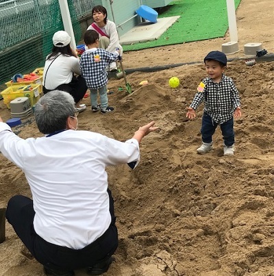 先生と砂場で遊ぶ様子