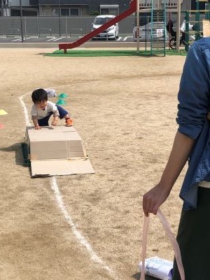 段ボールの上に乗っている子どもの写真