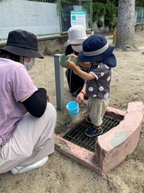 子どもが容器に水を入れている様子