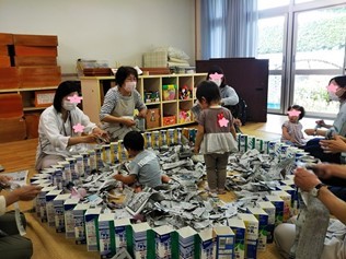 子どもが新聞プールで遊んでいる様子