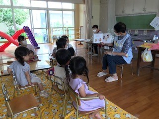 本を読んでいる先生と真剣に聞く子どもたち