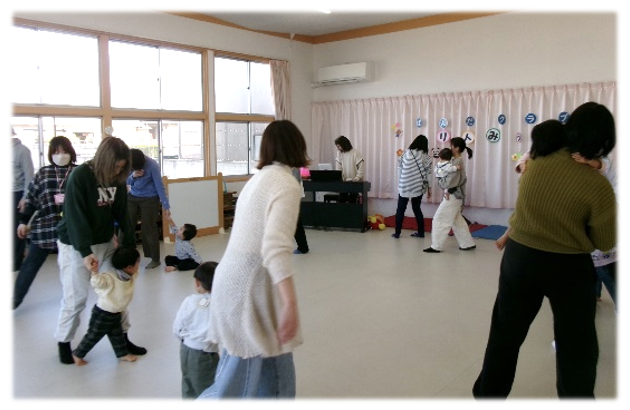 手をつないで回る親子たちの様子