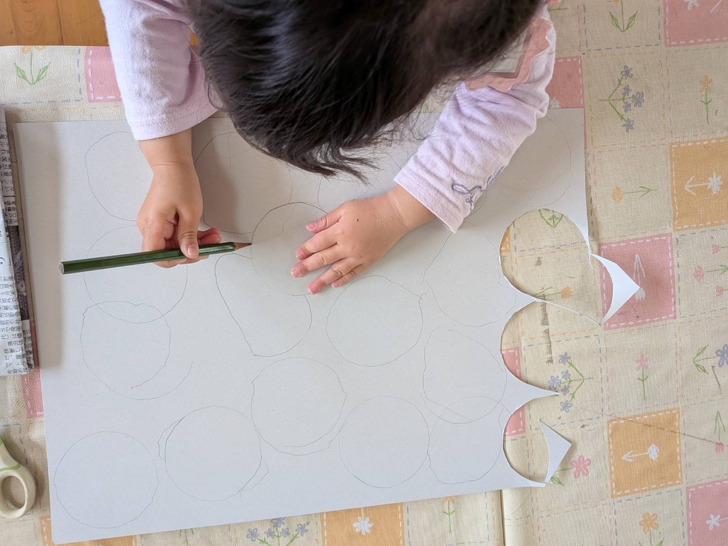 こいのぼりの目に使う厚紙に丸の形を写し取る子どもの様子