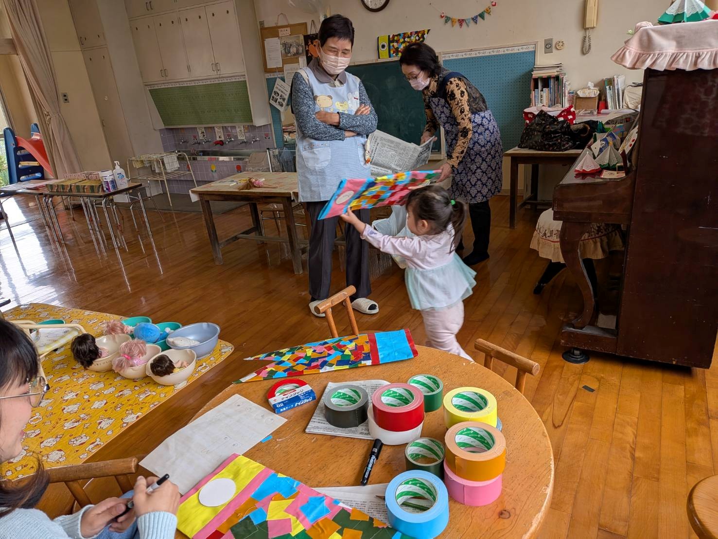 出来上がったこいのぼりをもって室内を回る子ども