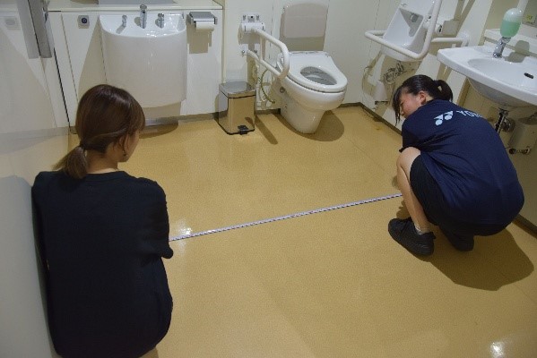 多目的トイレ内の寸法を調査する様子