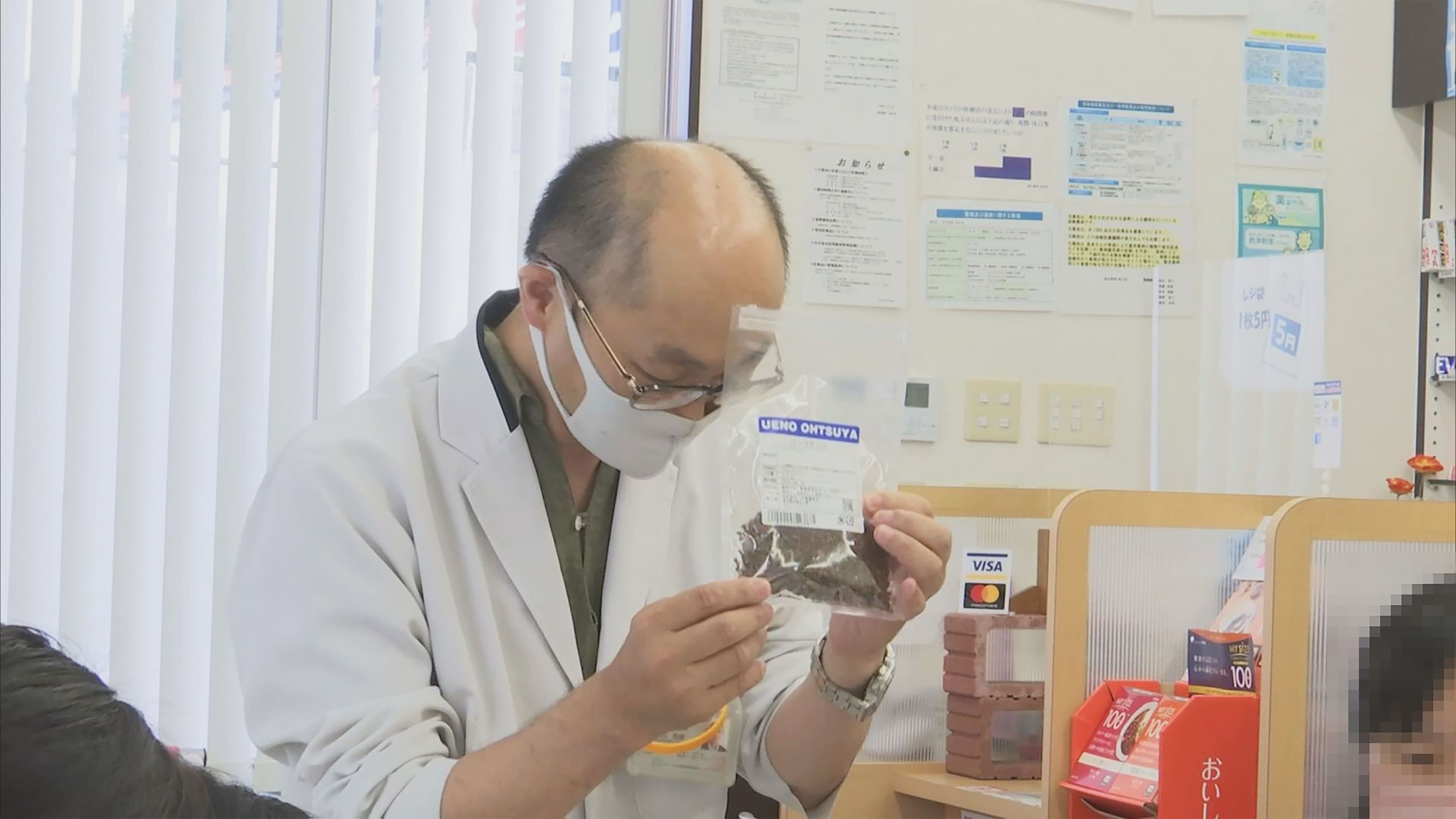 コーラの材料をもっている成広社長