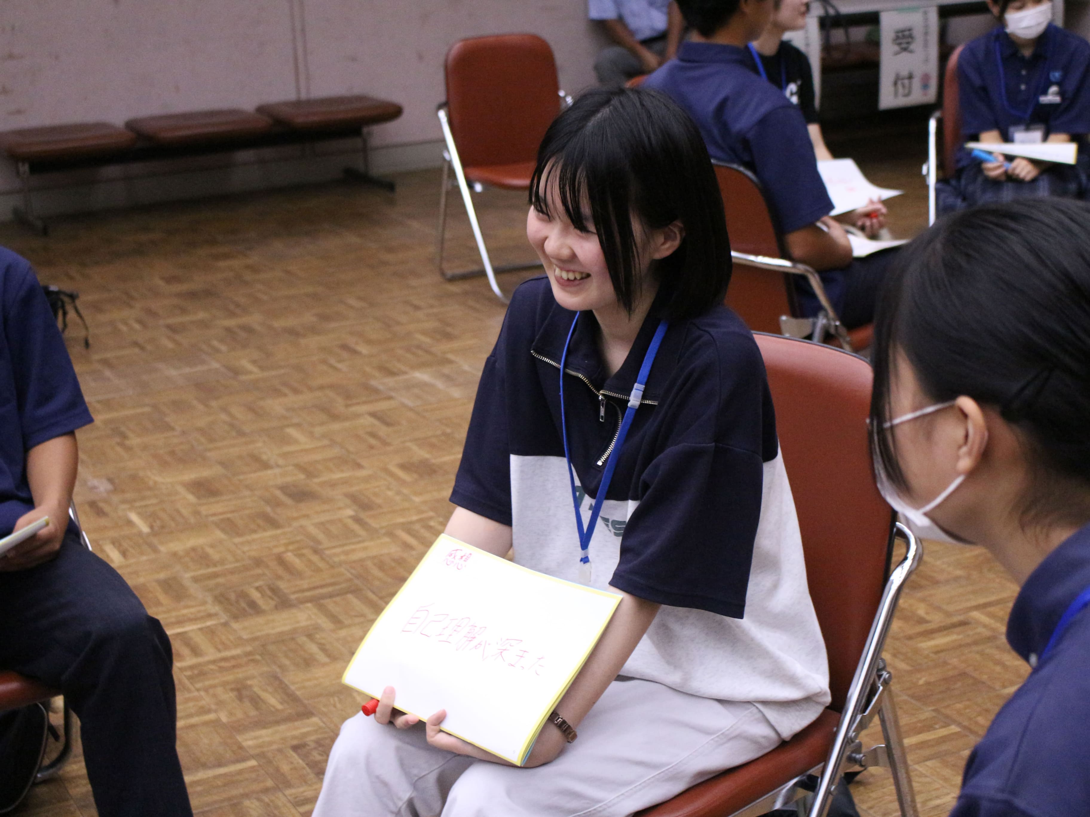 スケッチブックをもって会話する中高生の様子