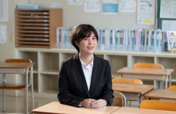 教室に座っている小学校教諭の写真