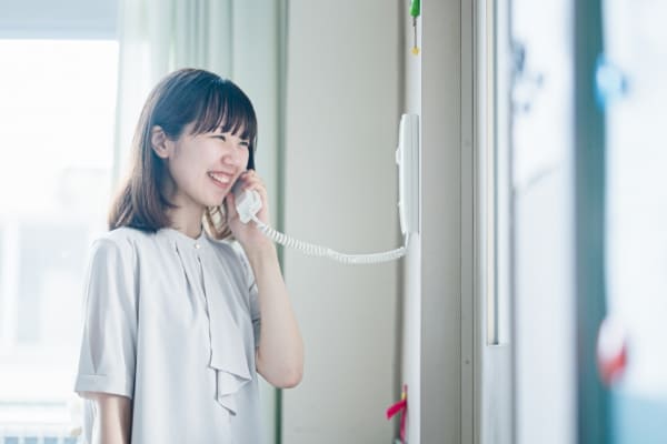 電話を受けて笑顔の先生の写真