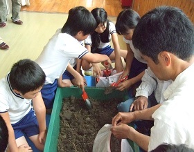 小学生たちが土を移し替える様子