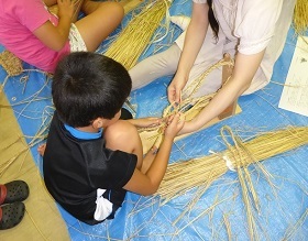 わらぞうりづくりをしている子どもの写真